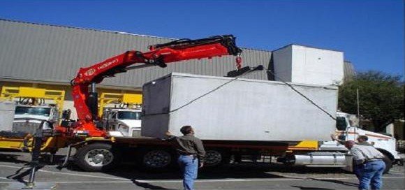 A knuckle boom septic crane truck lifting a precast tank